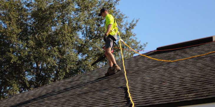Um carpinteiro instalando painéis solares em um telhado.