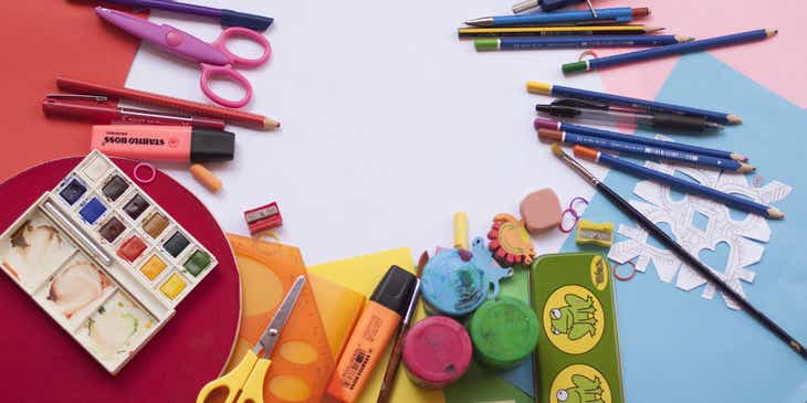 Un tavolo pieno di coloratissime forniture e materiali scolastici.