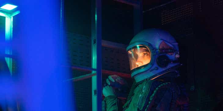 An astronaut aboard a spaceship in neon lighting.