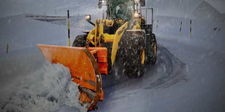 A plow removing snow from a mountain road.