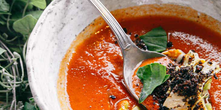 Eine leckere Gazpacho in einer weißen Suppenschüssel, die auf dem Tisch eines authentischen, spanischen Restaurants steht.