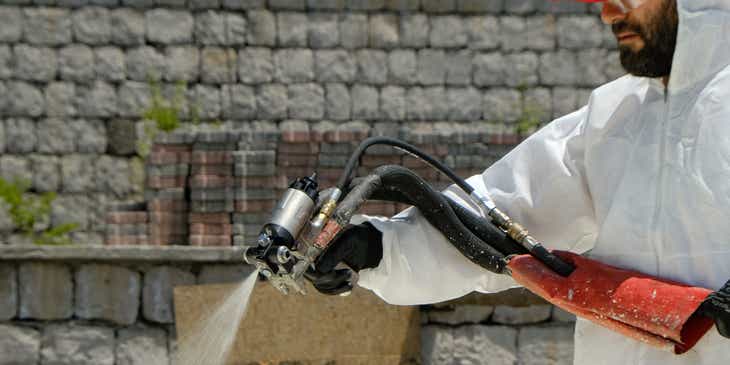 A person applying spray foam on a surface.