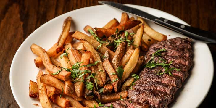 A steak served with fries in a steakhouse.
