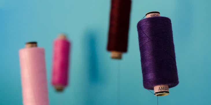 Different colored rolls of thread against a blue background at a tailor.