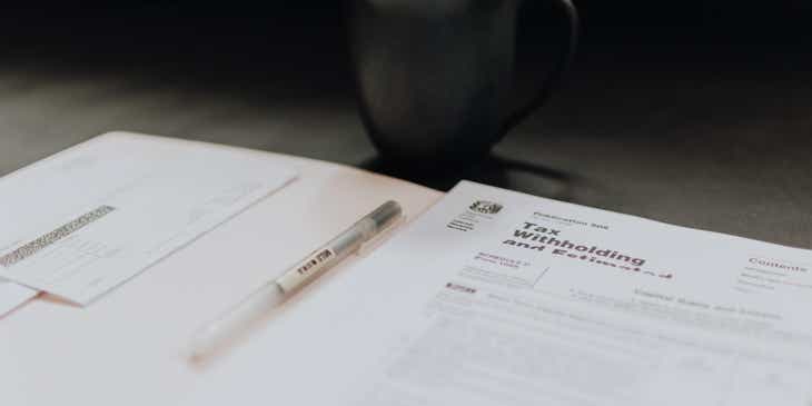 Formulário de declaração de impostos ao lado de uma caneta e uma caneca.