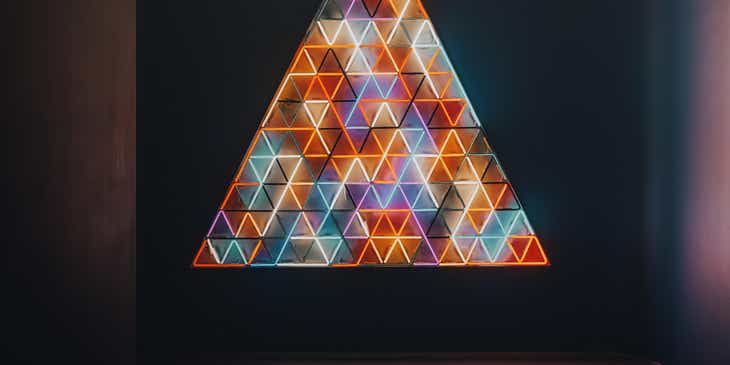 Karanlık bir odada sergilenen büyük ve parlak bir üçgen.