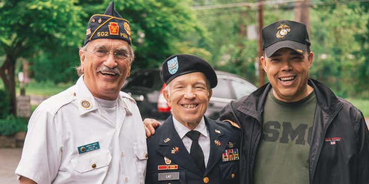 Een drietal veteranen die lachend poseren voor een ​​foto.