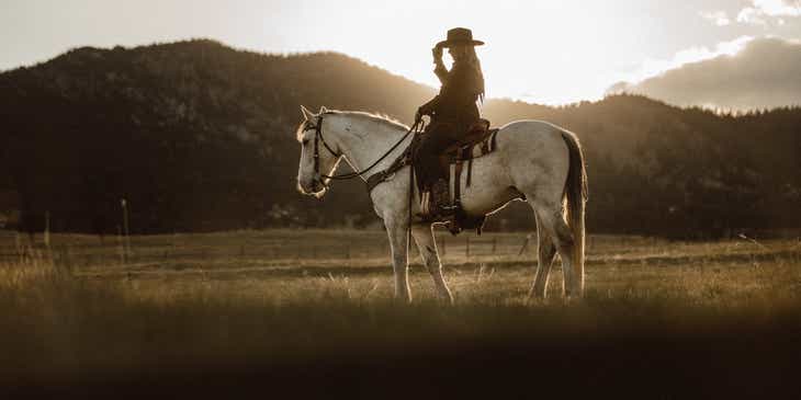 A person riding a horse in a western style.